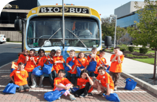  Young science students posing in front of the BioBus mobile research lab.