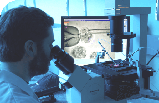  A Regeneron scientist looking into a microscope.