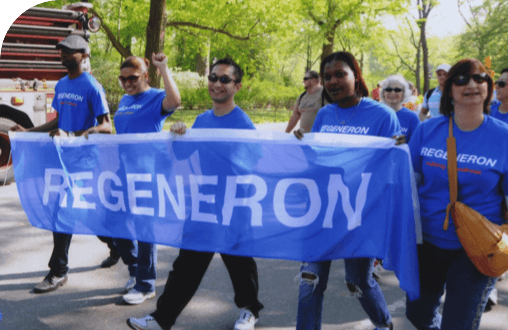  Regeneron employees holding a banner of the Regeneron logo.